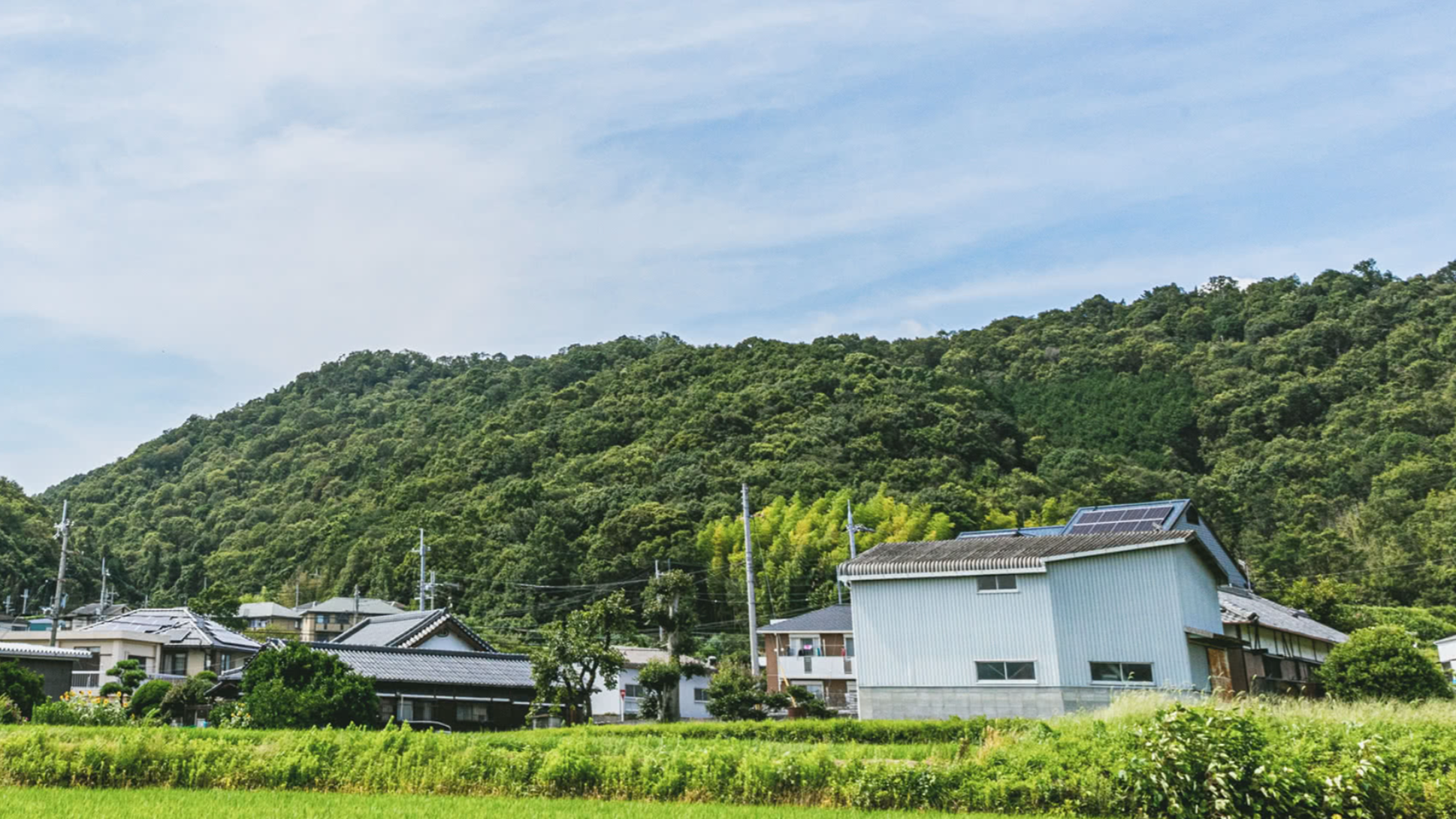Scenic view of a village with houses and greenery under a blue sky.
